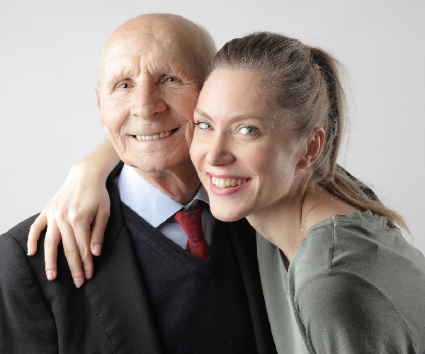 Mujer sonriente abrazando a un anciano