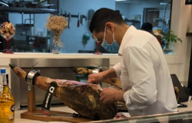 Persona cortando jamón serrano en Restaurante La Bodeguita de Javi Gracia